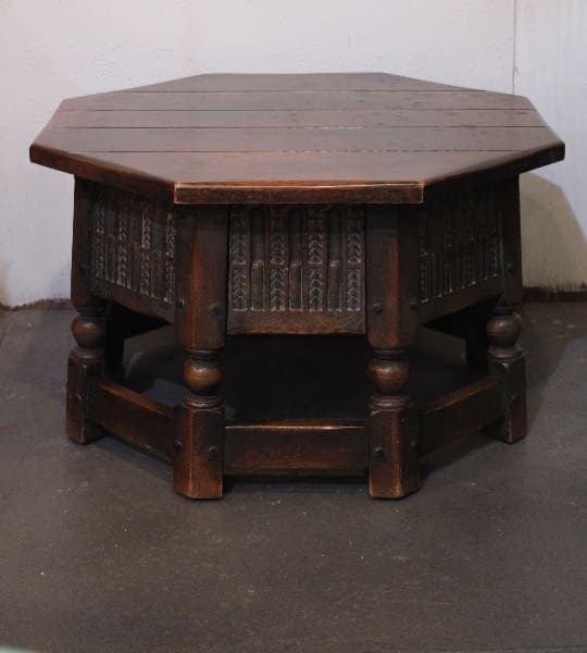 Octagonal wooden table with ornate carvings.