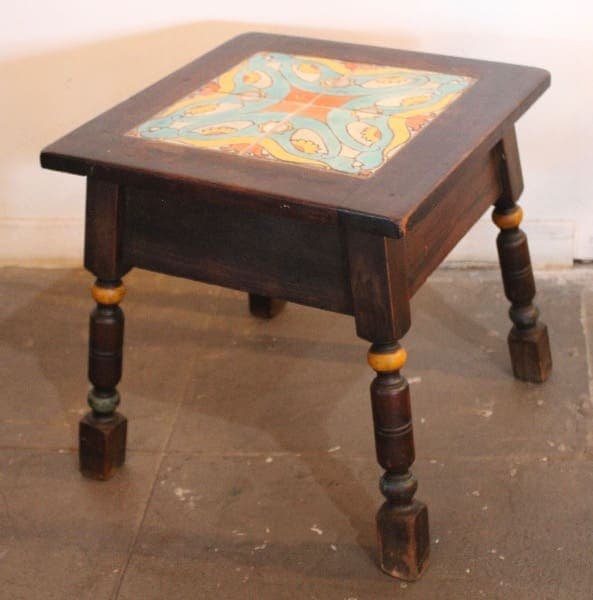 Wooden table with colorful tiled top.