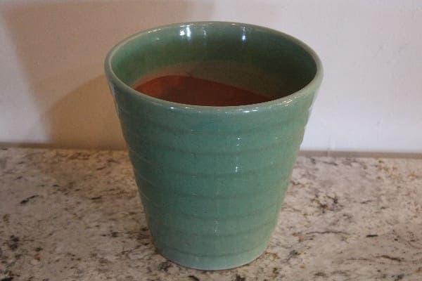 Green ceramic mug on granite countertop.
