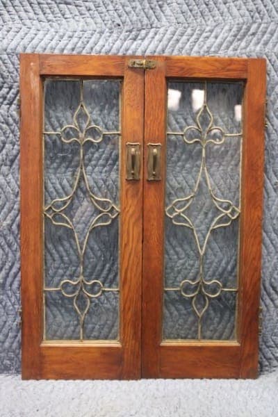 Vintage wooden cabinet doors with decorative glass.
