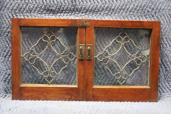 Wooden cabinet doors with decorative glass design.