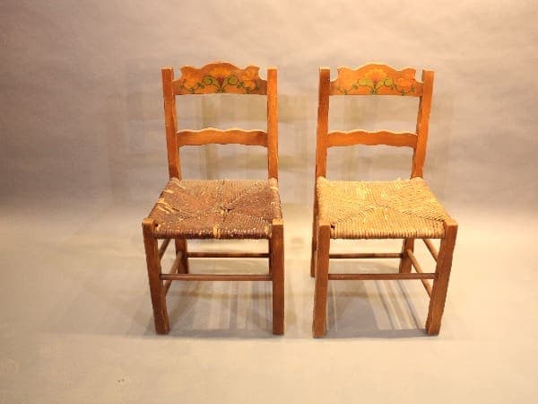 Two wooden chairs with woven seats.