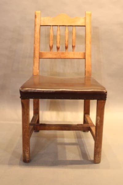 Wooden chair with cushioned brown seat.