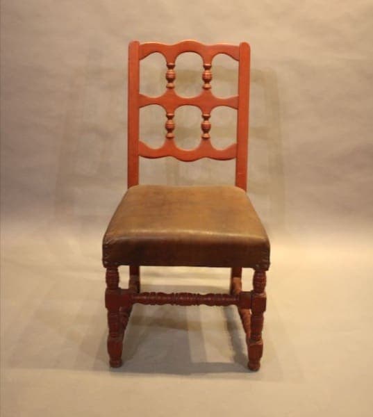 Wooden chair with tan cushioned seat.