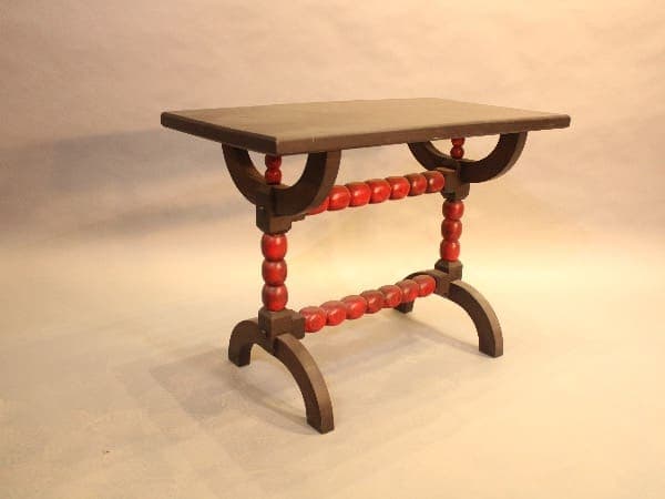 Wooden table with red spindle legs.