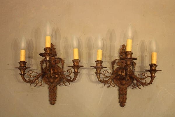 Vintage wall sconces with ornate brass design.