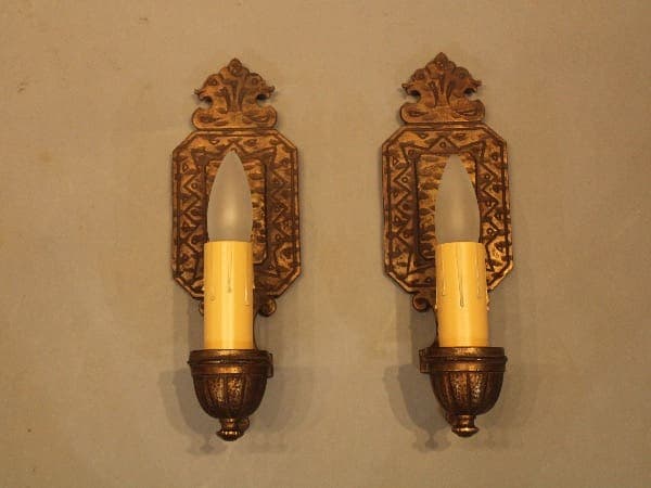 Two vintage wall sconces with candles.