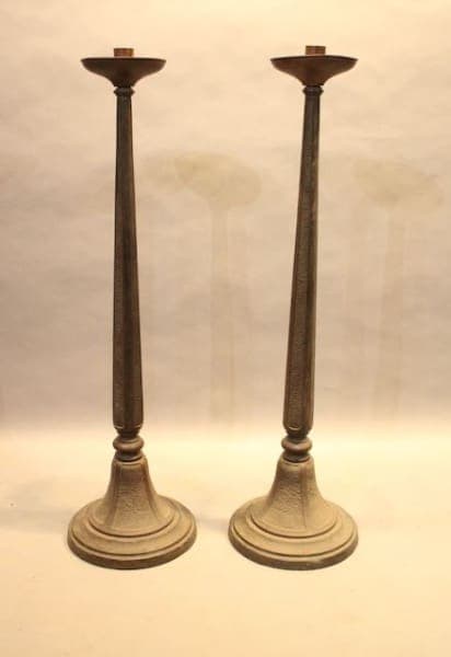 Two tall, wooden candle holders on display.