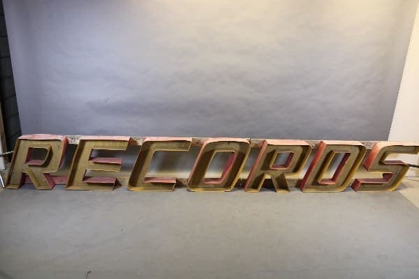 Vintage 'RECORDS' sign on display stand.