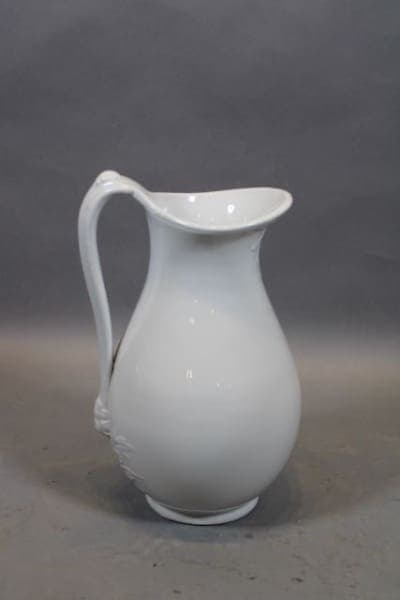 White ceramic pitcher on gray background.