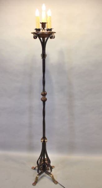 Ornate wrought iron floor lamp with candles.