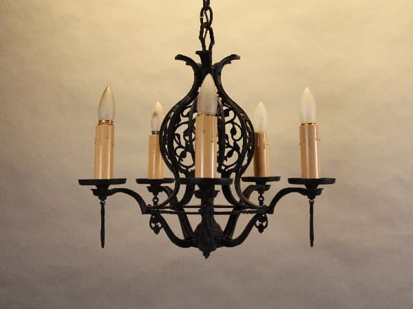 Ornate black chandelier with five candles.
