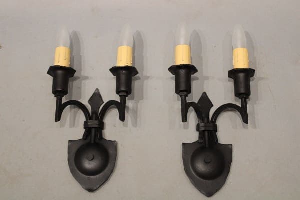 Black metal wall sconces with candle bulbs.