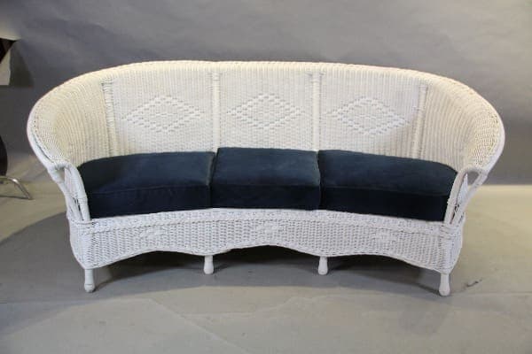 White wicker sofa with blue cushions.