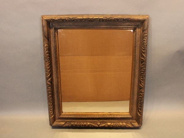 Ornate framed mirror with carved details.