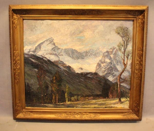 Painting of mountains in an ornate frame.