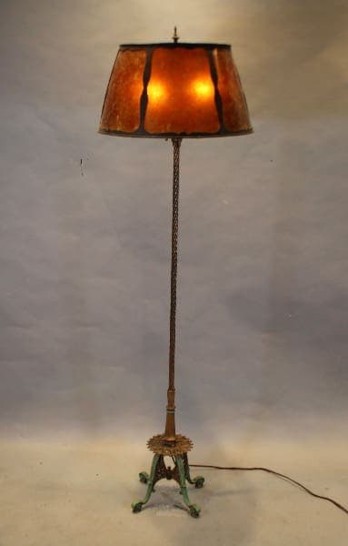 Vintage floor lamp with illuminated shade.