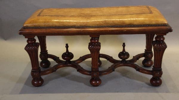 Ornate wooden bench with cushioned seat.