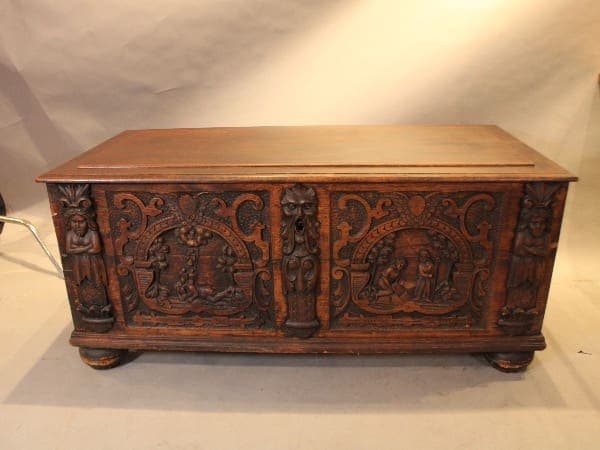 Ornate wooden chest with carved figures.