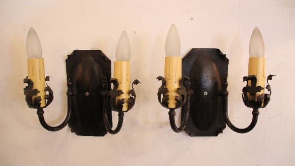 Vintage wall sconces with ornate black design.