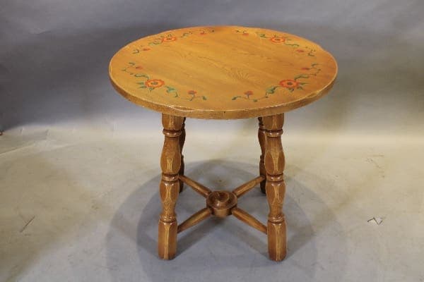 Round wooden table with floral design top.