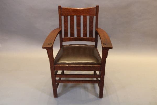 Wooden chair with slatted backrest and arms.