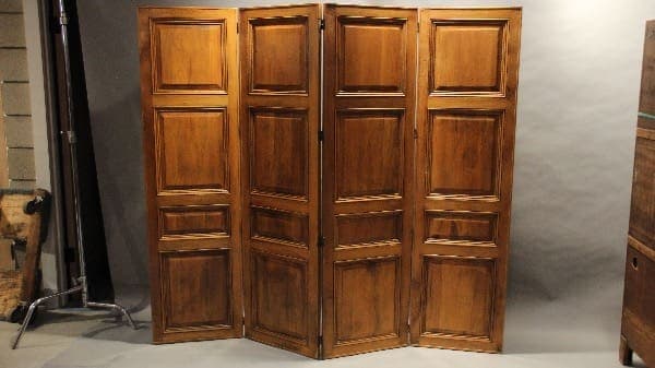 Wooden folding room divider with panels.