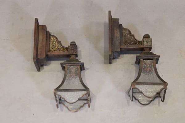 Two vintage wall-mounted lanterns on display.