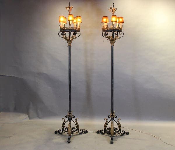 Two ornate iron floor lamps with lights.