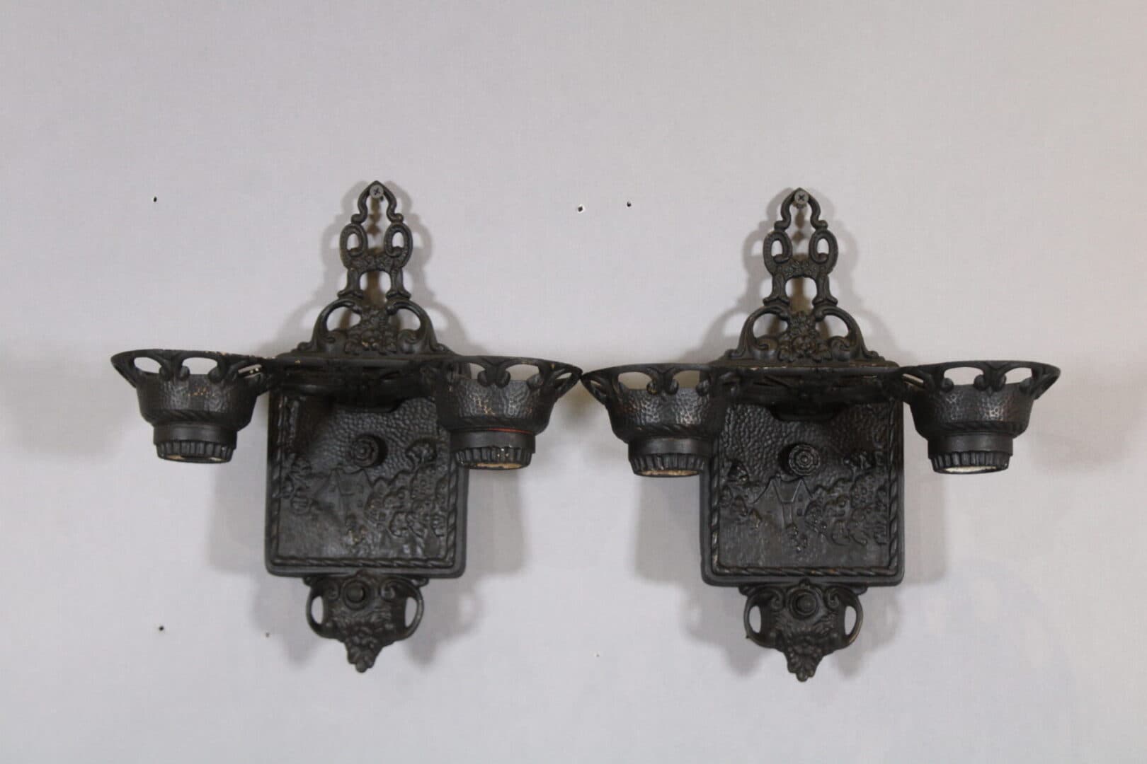 Two ornate black metal wall sconces.