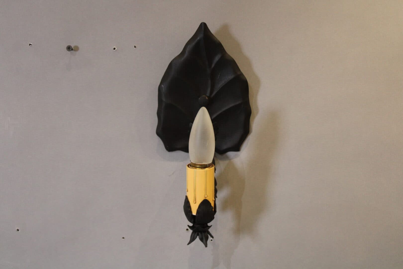 Wall-mounted light fixture with leaf design.