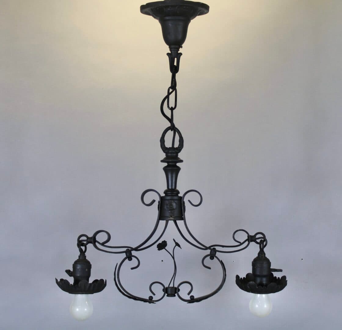 Vintage wrought iron chandelier with two bulbs.