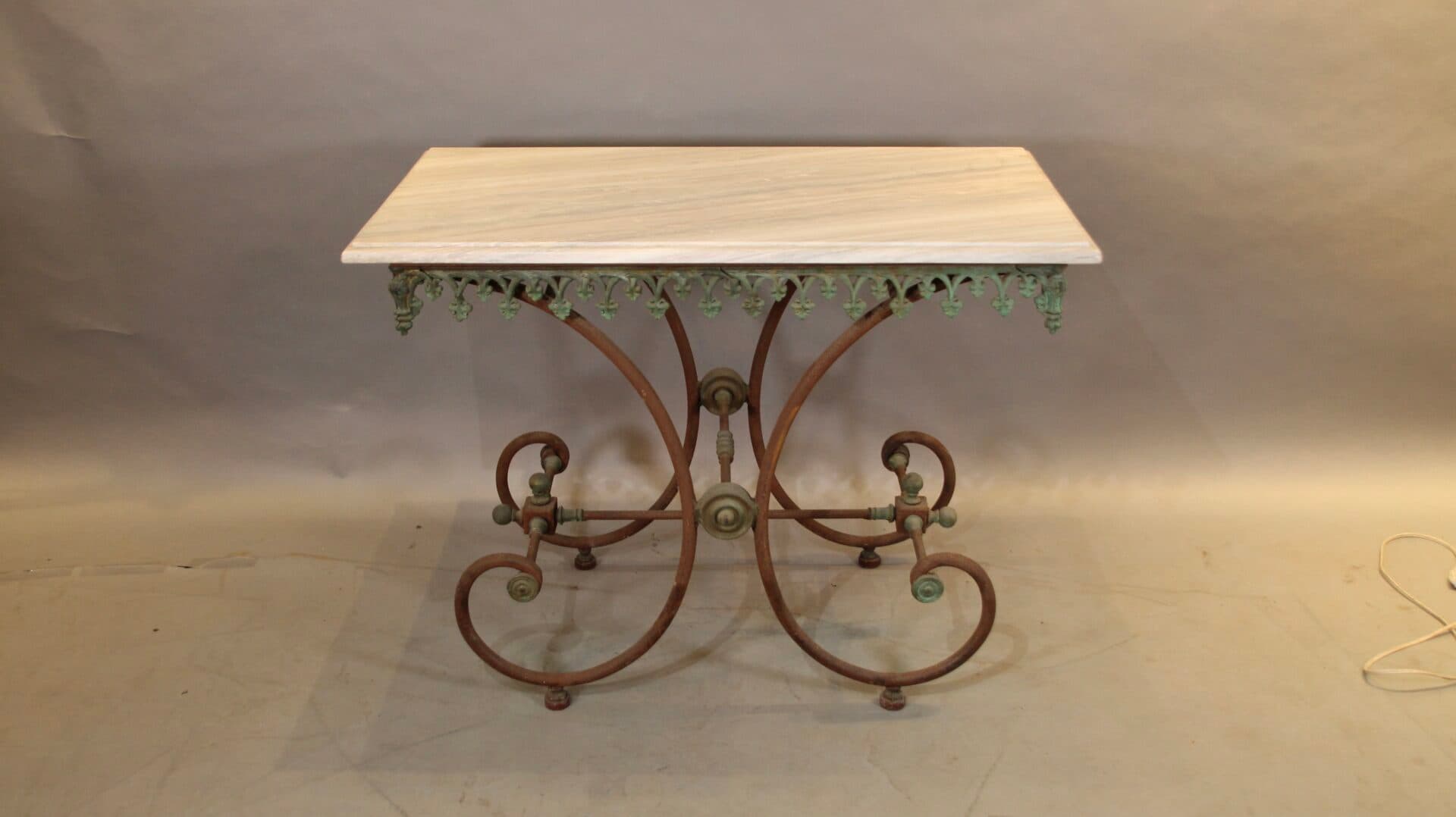 Decorative wrought iron table with ornate base.