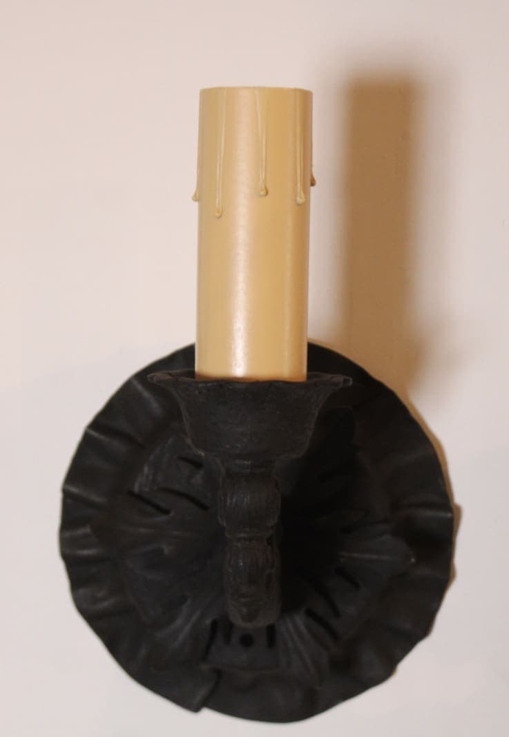 Black sconce with cream wax candle