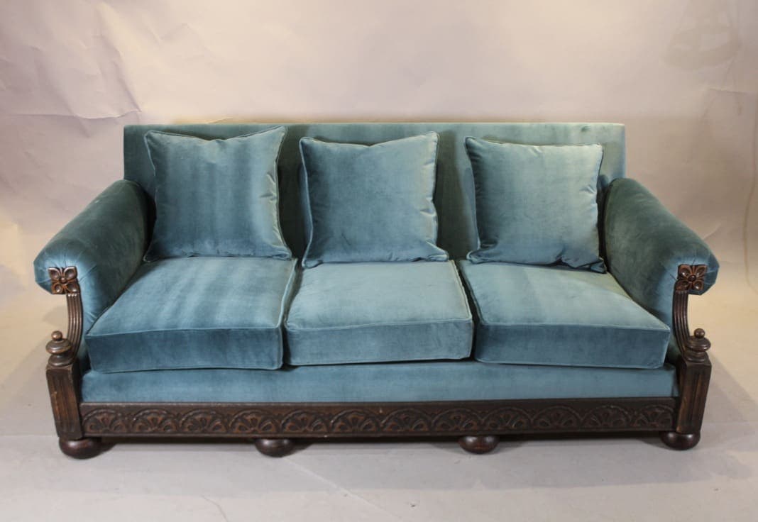 Teal velvet three-seat sofa with carved wood