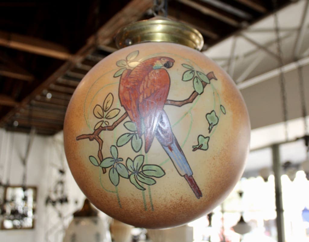 Hanging globe lamp with painted parrot