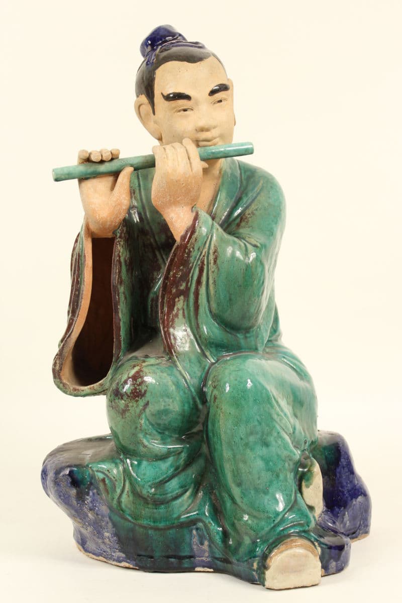 Large Asian polychrome decorated stoneware figure of a flute player