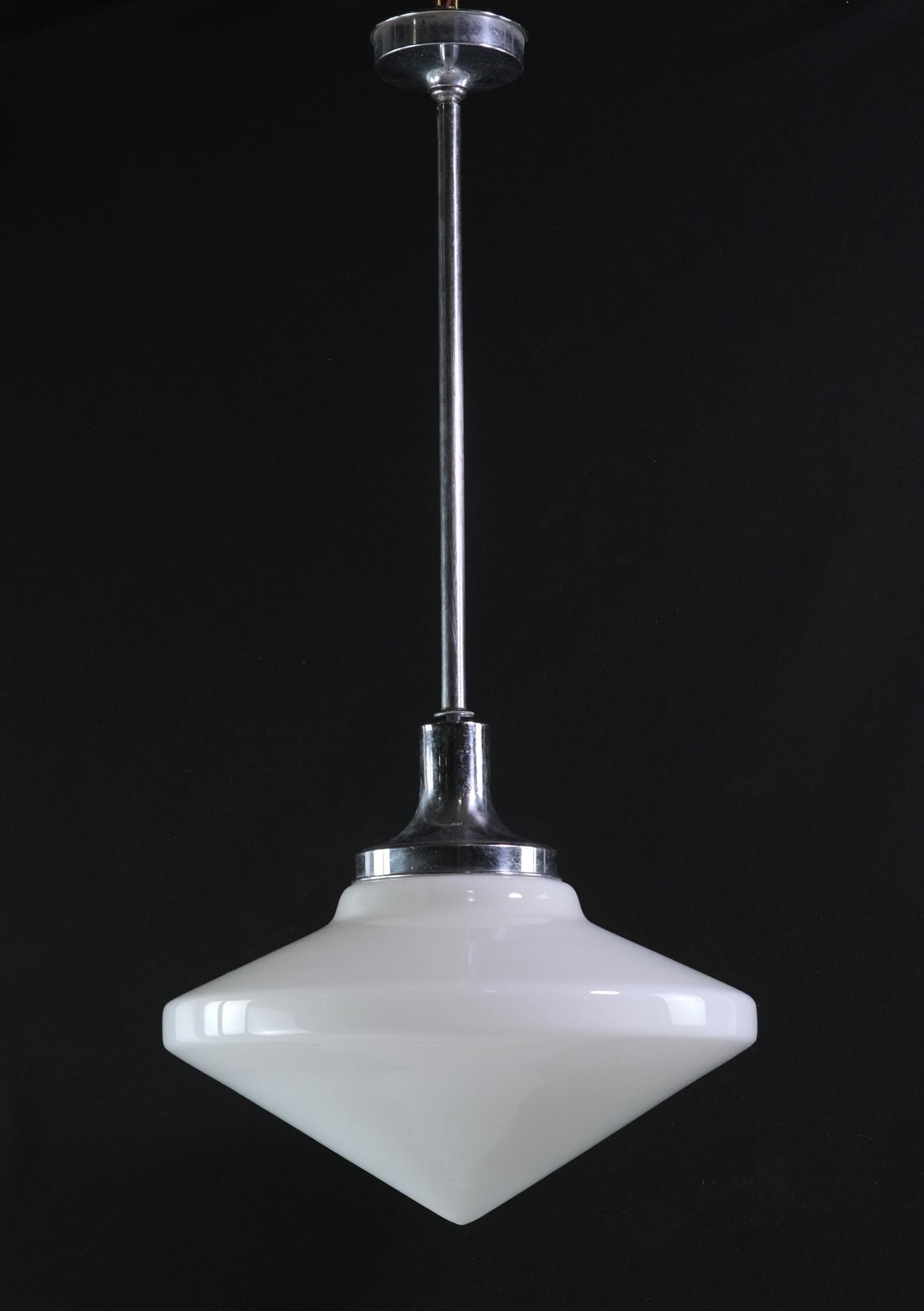 Mid-century pendant light with a white conical glass shade and polished nickel pole fitter.