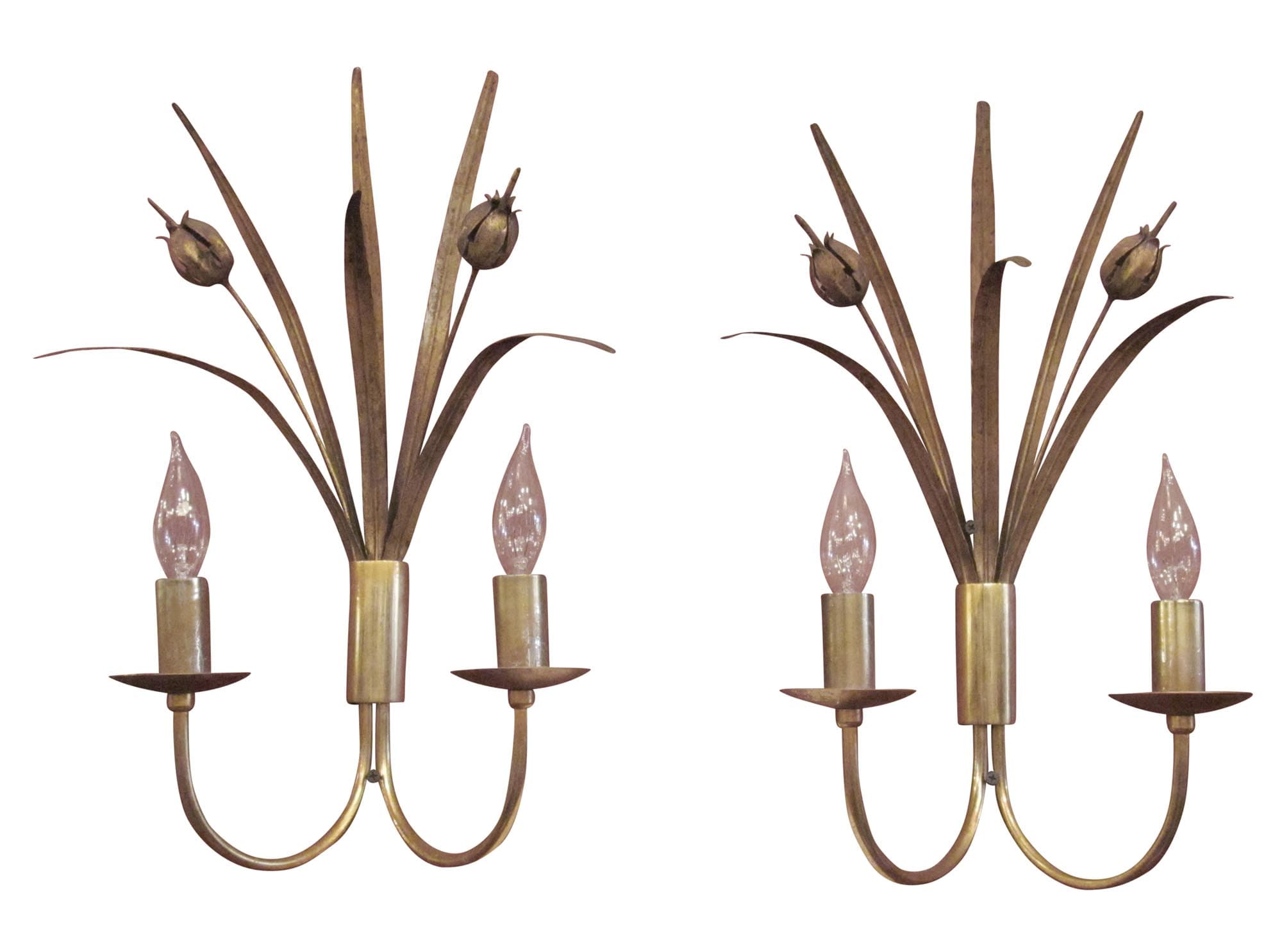 Pair of French-style two-arm wall sconces shown as a pair, each with candle-style bulbs and decorative leaf-like tole accents in an antique brass finish.