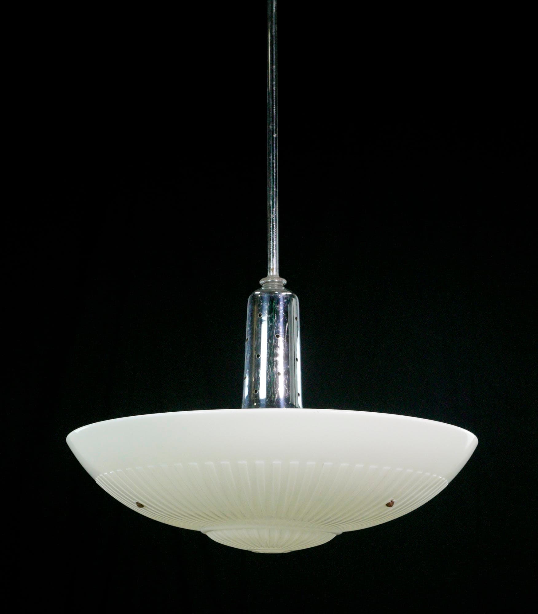 Mid century pendant light with a white milk glass saucer shade and a chrome pole, shown from below.
