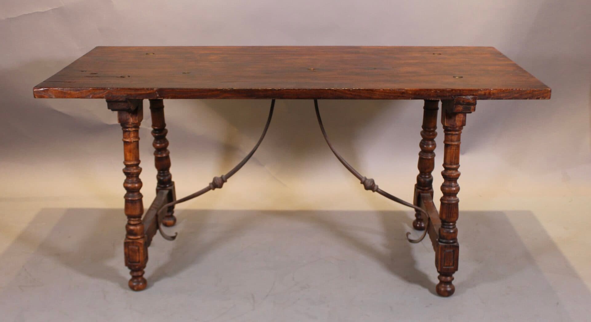 Antique wooden table with turned legs in light bg