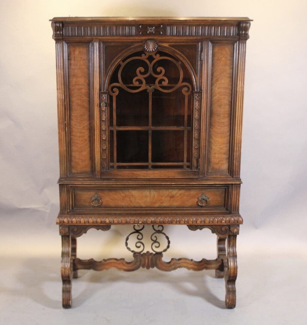 Antique carved wooden cabinet with glass door